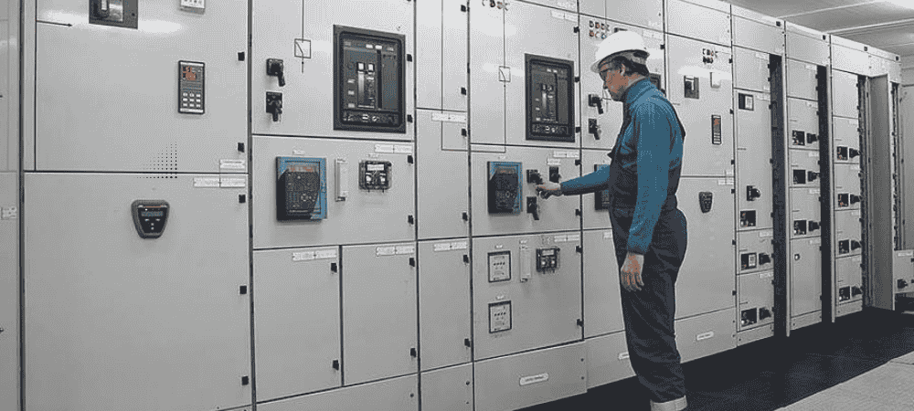 Engineer operating switchgear panel, representing trusted industrial electrical solutions
